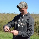 ECC Conservation Technology student studying butterfly in meadow